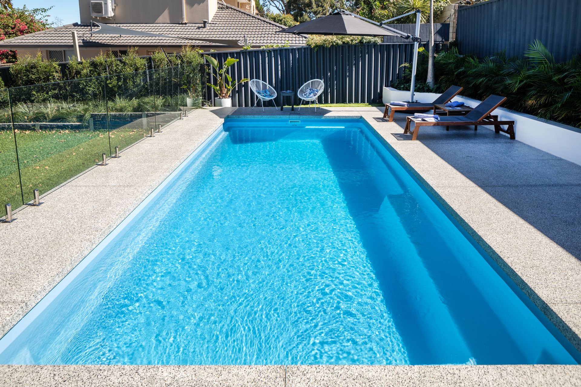 A White House With a Large Swimming Pool in the Backyard — Gibson Family Pools Pty Ltd In Bulahdelah, NSW