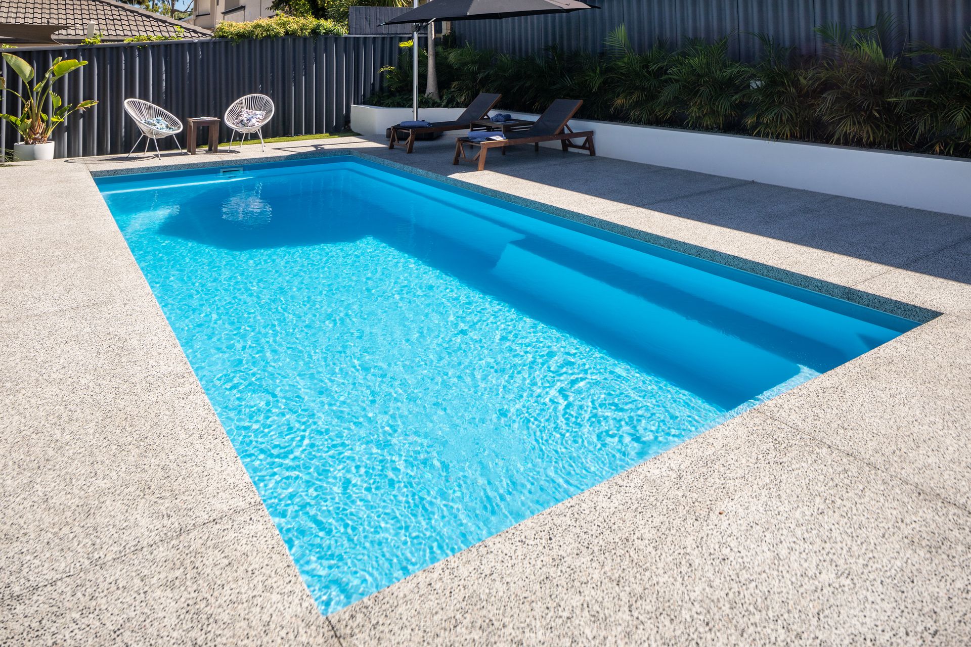There is a Large Swimming Pool in the Backyard of a House — Gibson Family Pools Pty Ltd In Port Macquarie, NSW