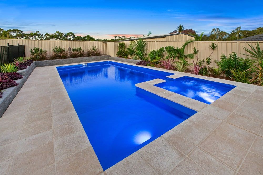 A Large Swimming Pool With a Fence in the Background — Gibson Family Pools Pty Ltd In Harrington, NSW