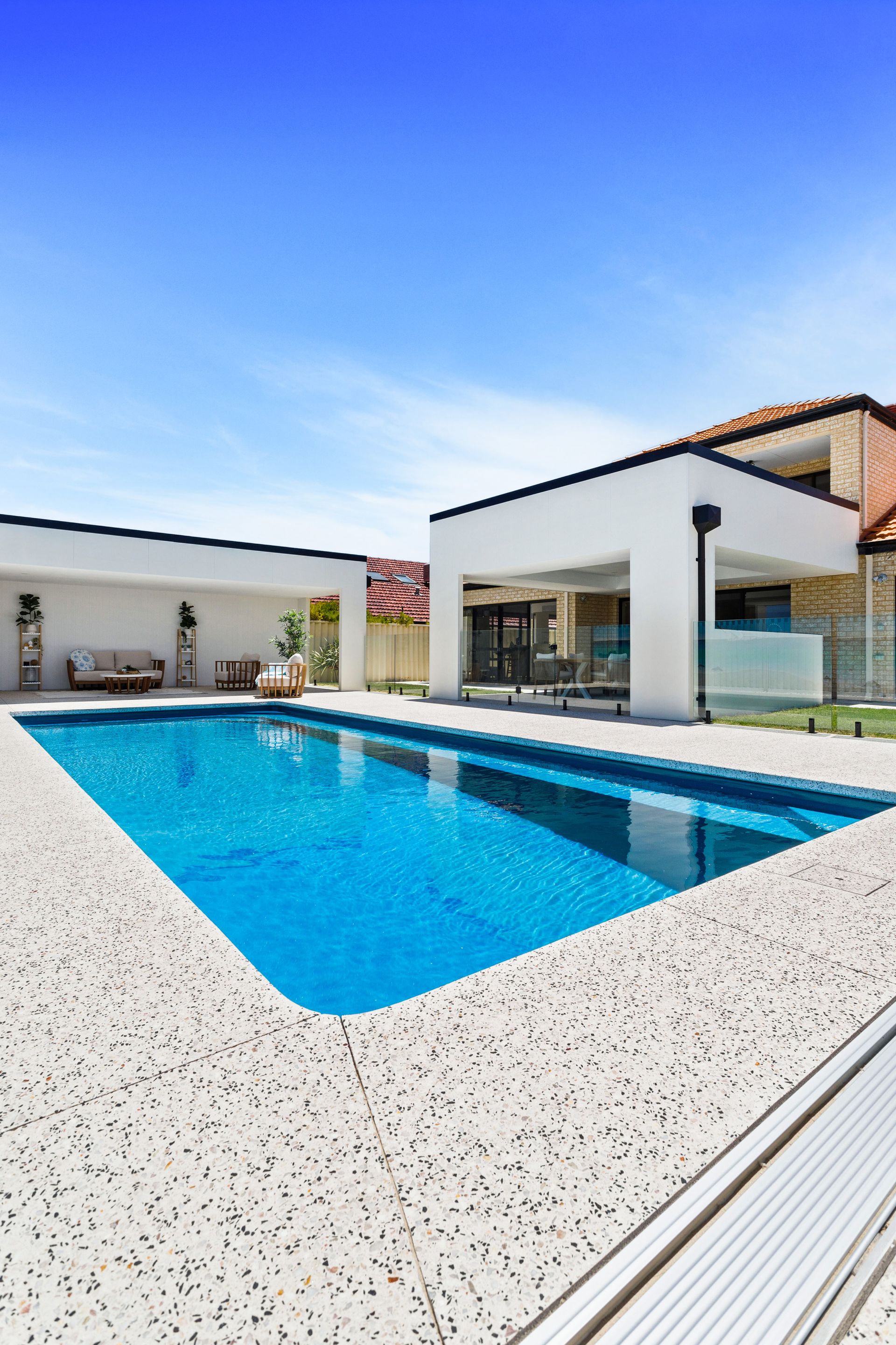 A House With a Large Swimming Pool in Front of It — Gibson Family Pools Pty Ltd In Taree, NSW
