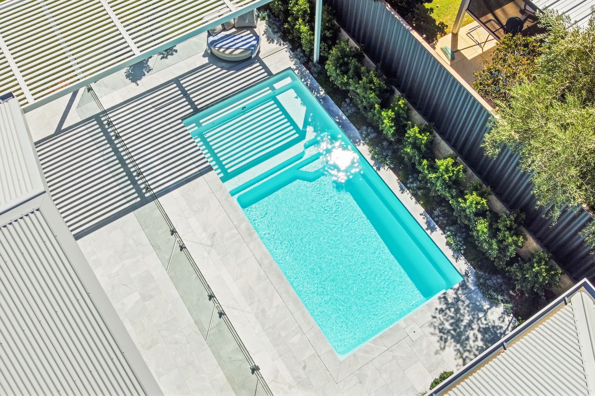A Large House With a Swimming Pool in Front of It — Gibson Family Pools Pty Ltd In Forster, NSW