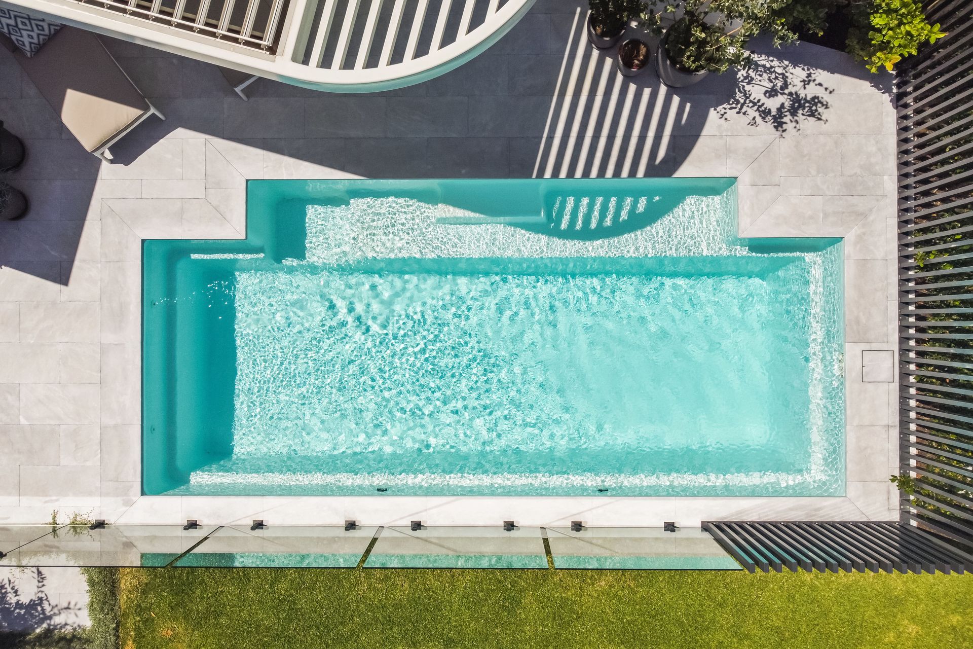 A Large Swimming Pool Is Lit Up At Night — Gibson Family Pools Pty Ltd In Port Macquarie, NSW