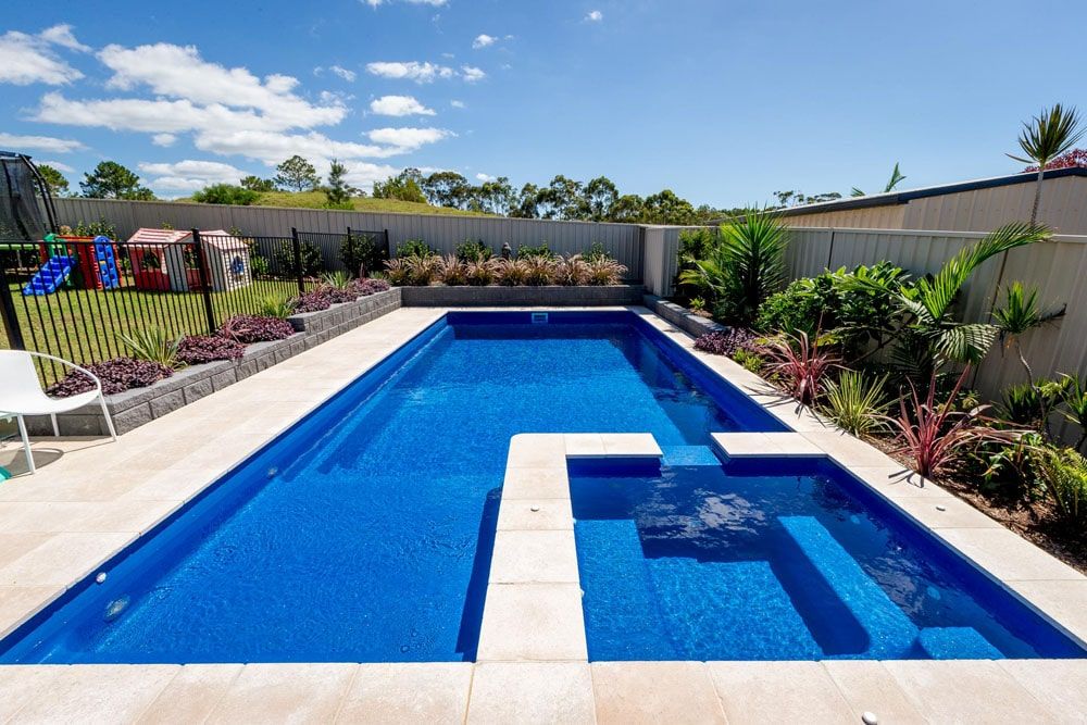 A Large Blue Swimming Pool With a White Border — Gibson Family Pools Pty Ltd In Nambucca Heads, NSW