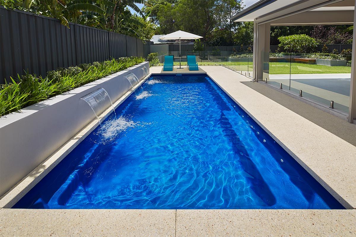 A House With a Large Swimming Pool in Front of It — Gibson Family Pools Pty Ltd In Port Macquarie, NSW