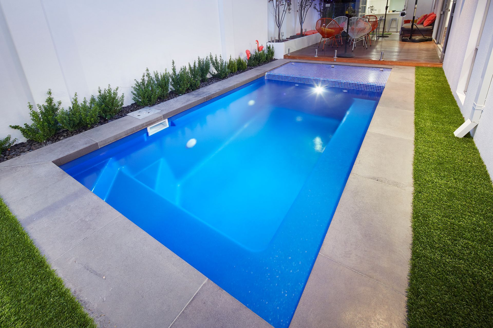 A Family Is Laying On A Blue Raft In A Swimming Pool — Gibson Family Pools Pty Ltd In Port Macquarie, NSW