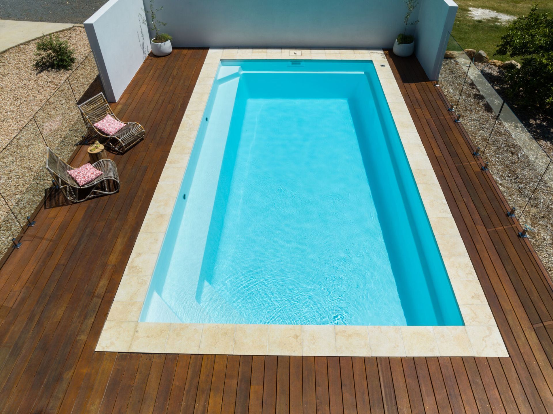 A Large Swimming Pool With A Glass Fence Around It — Gibson Family Pools Pty Ltd In Port Macquarie, NSW