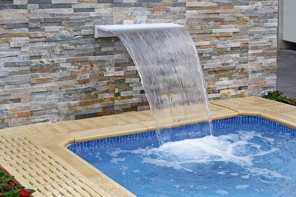 A Waterfall Is Coming Down The Side Of A Swimming Pool — Gibson Family Pools Pty Ltd In Port Macquarie, NSW