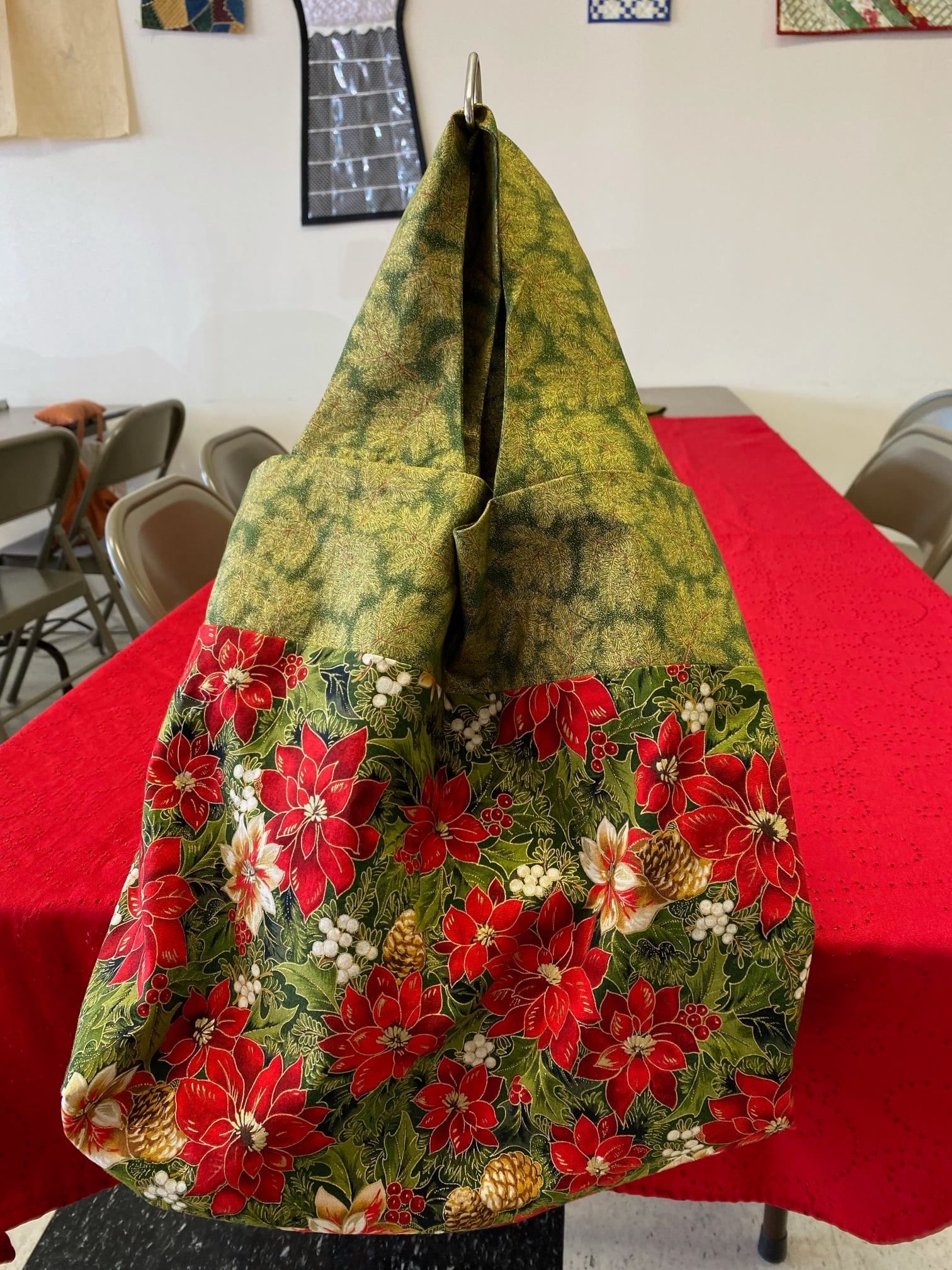 Floral green and red fabric cone centerpiece on a red tablecloth in a room