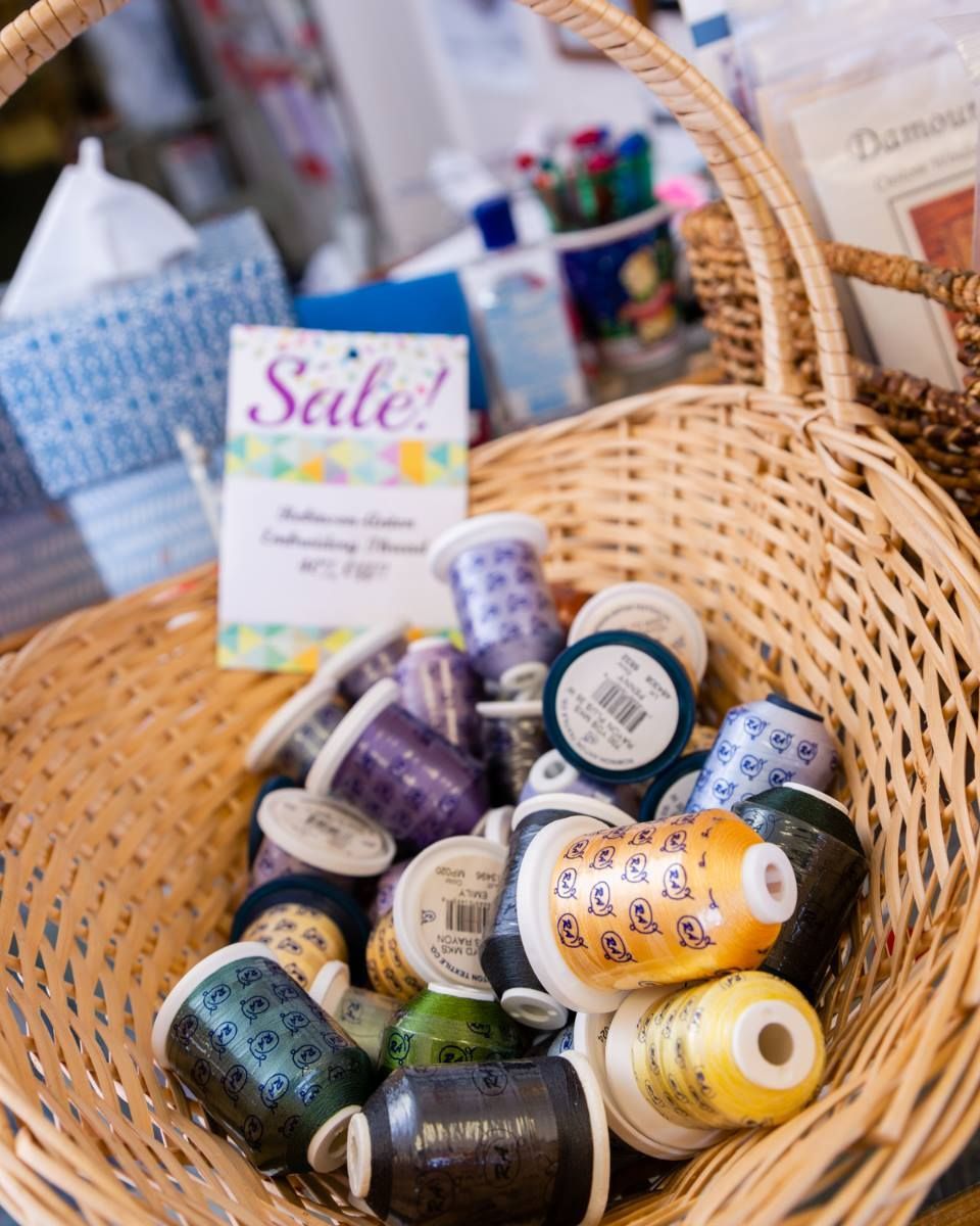 Wicker basket filled with colorful small jars and bottles at a sale display