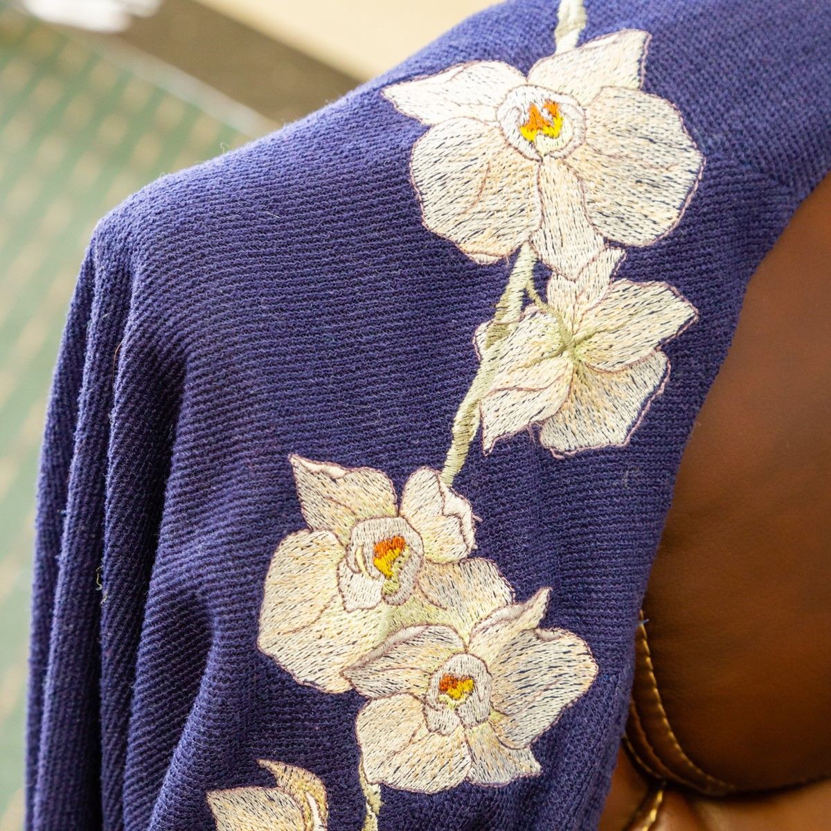 Purple fabric with white floral embroidery on a brown chair arm