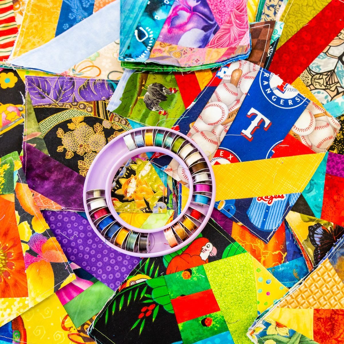 Colorful patchwork fabric collage with a circular ring centerpiece and bold red, yellow, blue, and green patterns