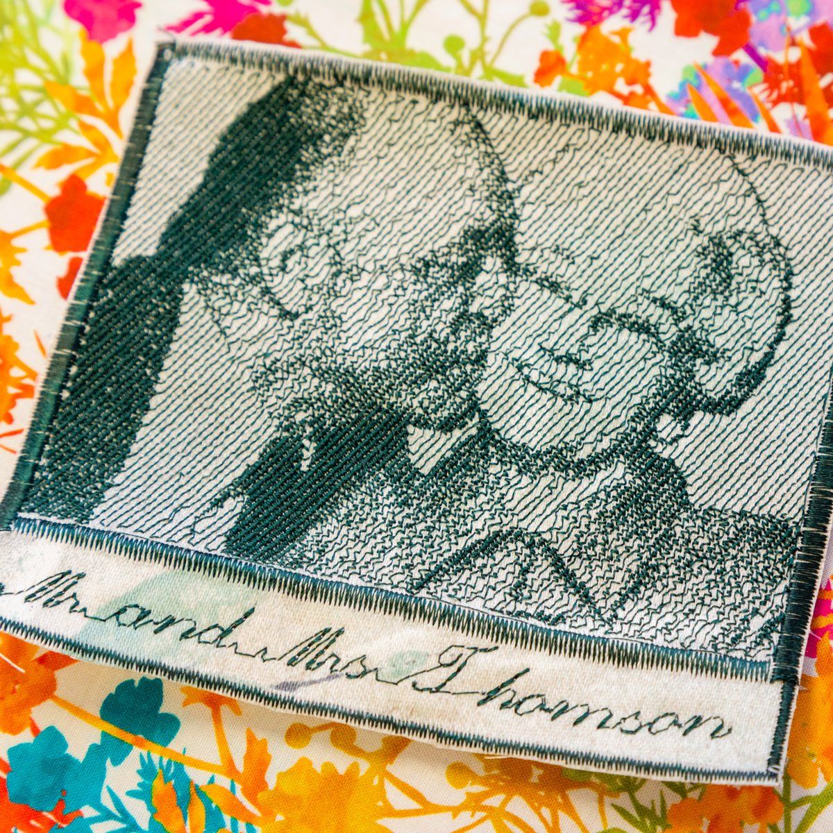 Two men’s portrait on a green postage stamp with white border on a colorful patterned background