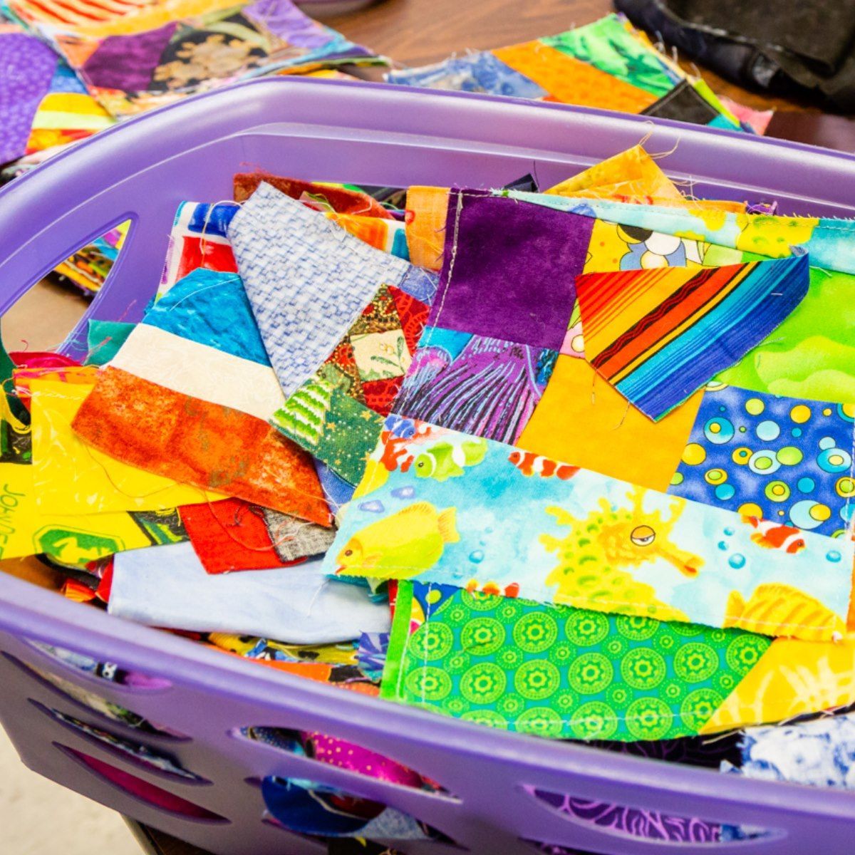 Basket of colorful fabric quilt scraps and patches in assorted patterns and bright colors