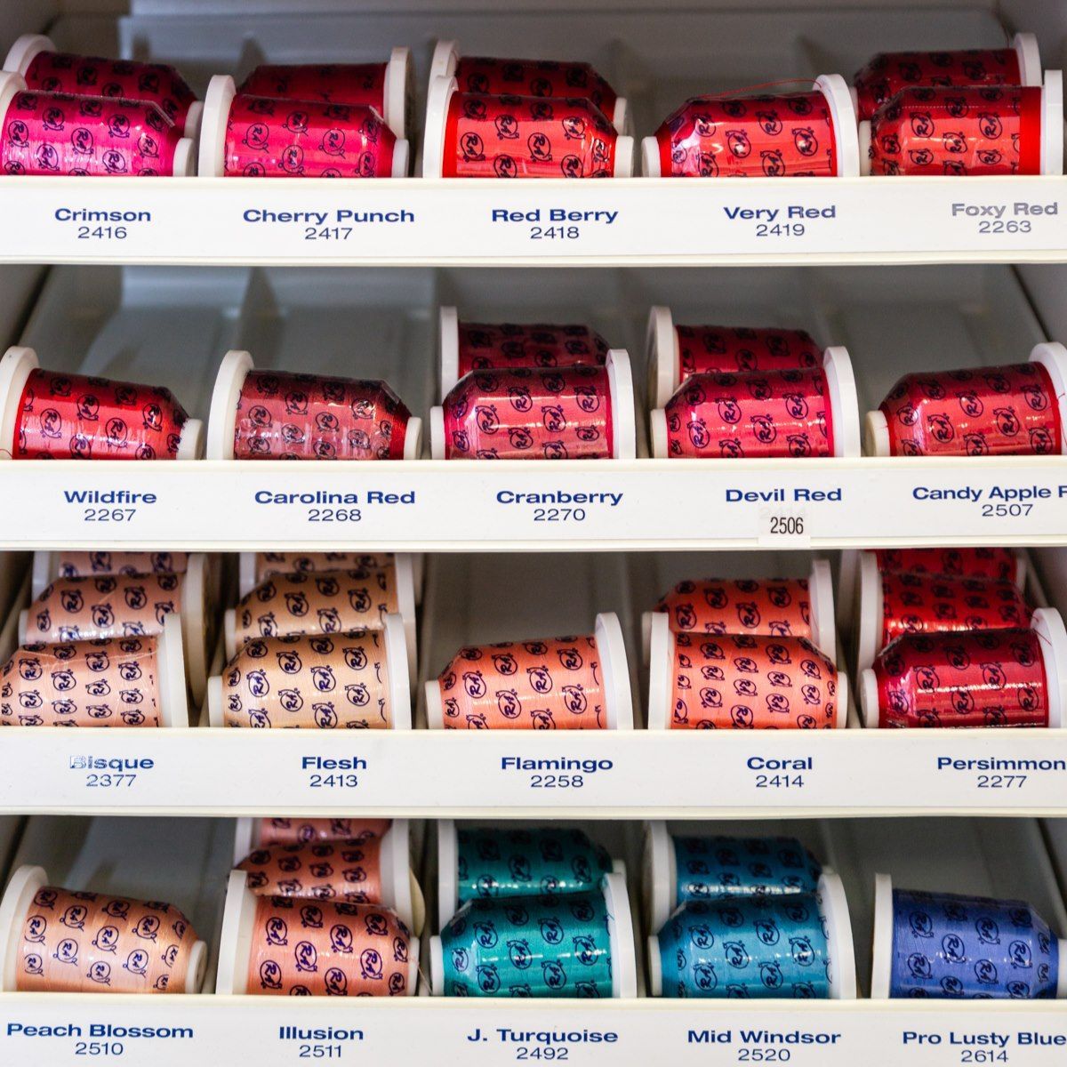 Rows of colorful packaged candy bars on white store shelves with flavor labels visible.