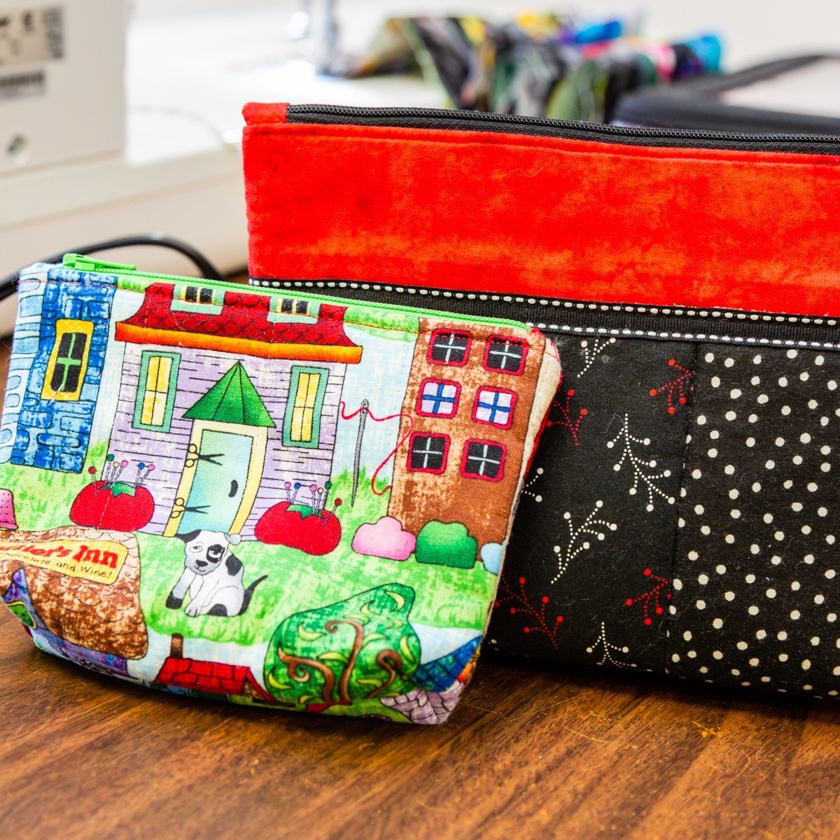 Colorful fabric pouches on a wooden table, including a red pouch and a black star-patterned pouch.