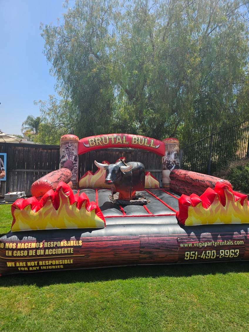A mechanical bull is laying on top of an inflatable pool.