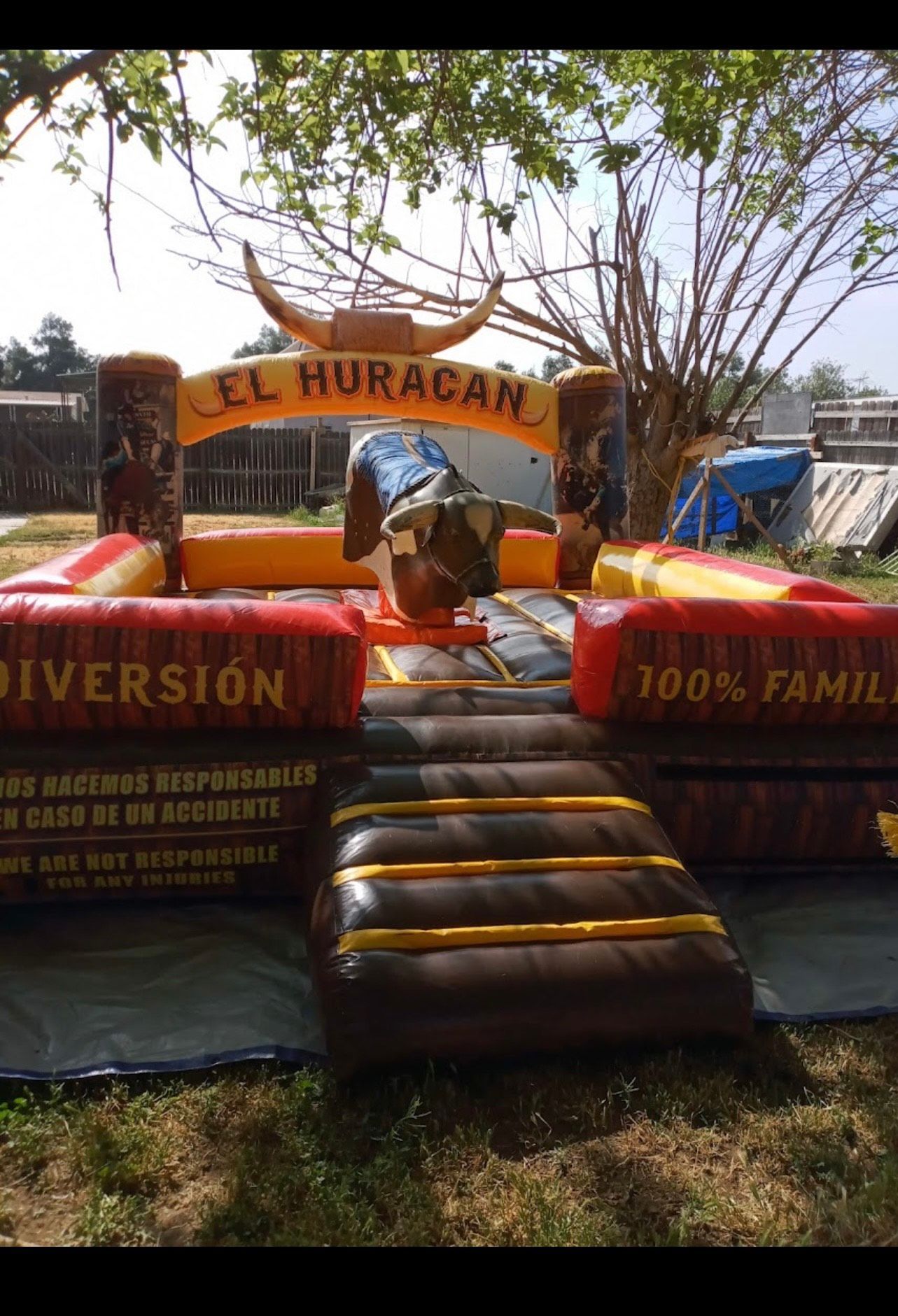 A mechanical bull is sitting on top of an inflatable mat