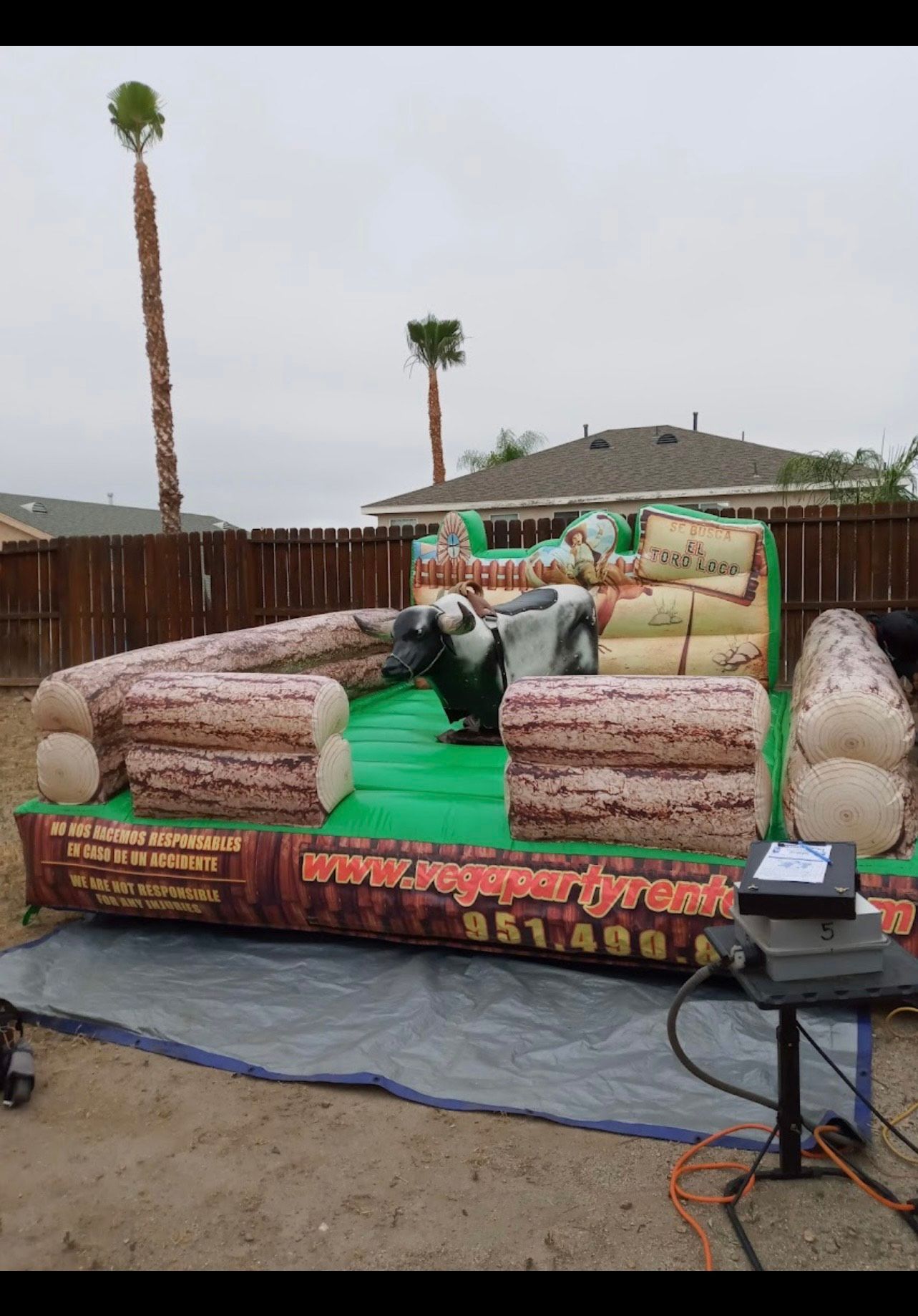 A young boy wearing a helmet is riding a mechanical bull.