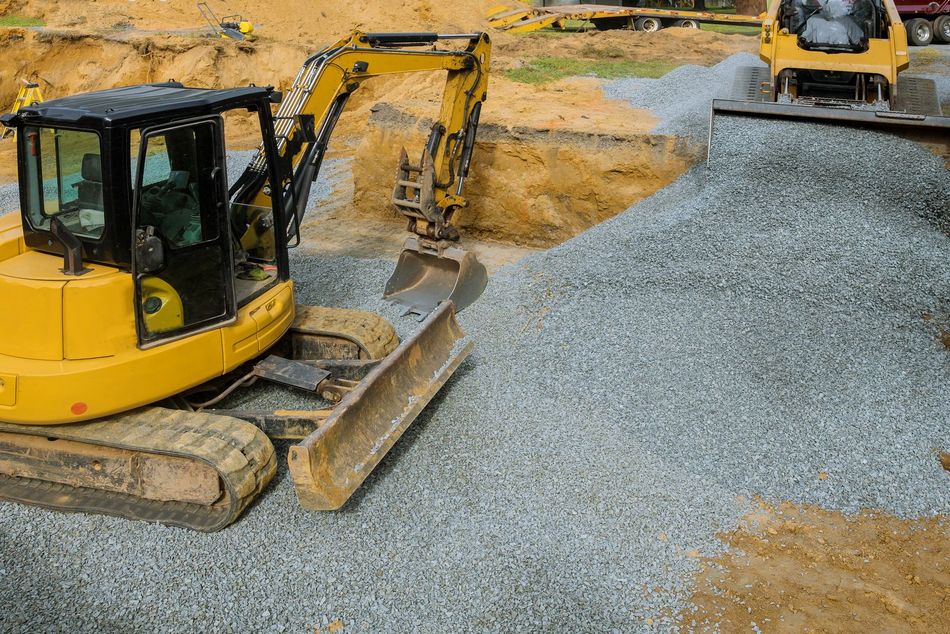 Two bulldozers are working on a construction site.