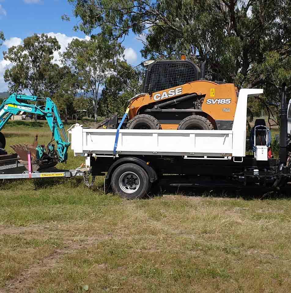 A Case Skid Steer Is On The Back Of A Dump Truck — Rockyview Excavations In Rockyview, QLD