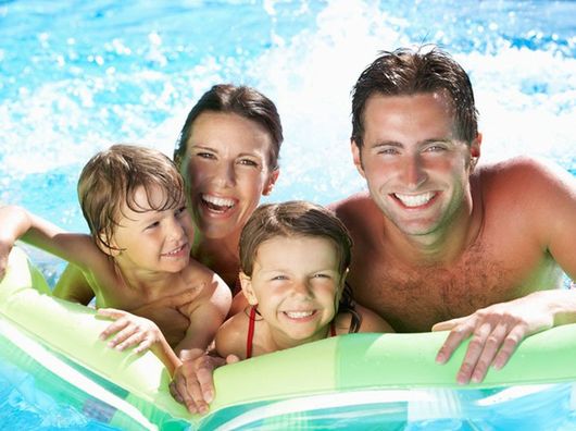 Family On Holiday In Swimming Pool