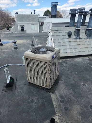 Man in cap fixing wall-mounted air conditioner.