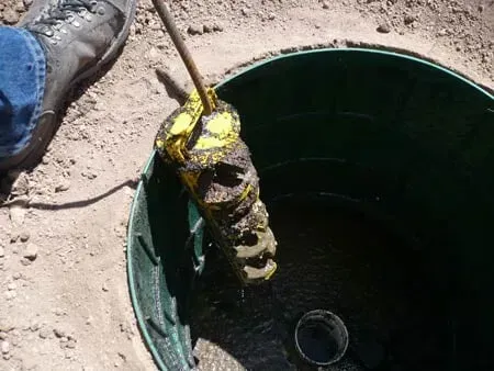 A person is holding a yellow object in a hole in the ground.