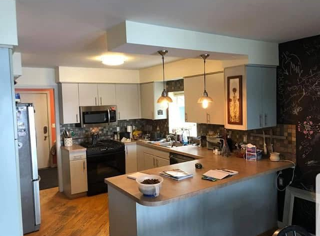 Modern kitchen with island, hanging lights, stainless appliances, and wood cabinets