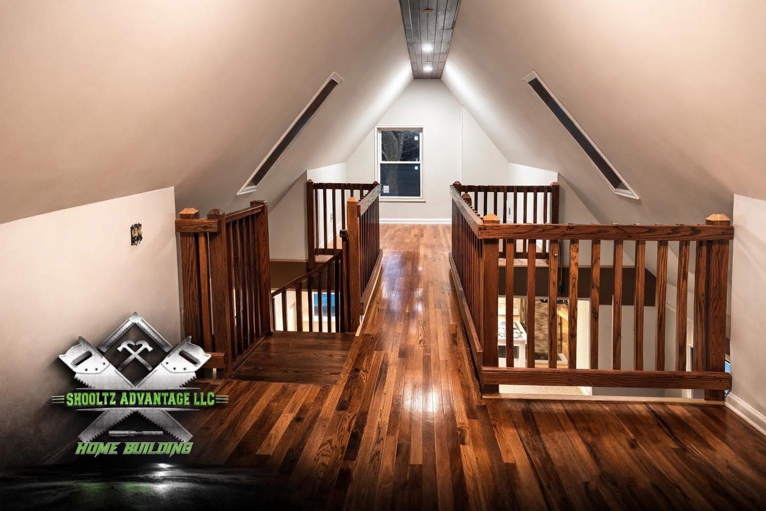 Attic hallway with polished wood floors, railings, and a centered window at the far end.