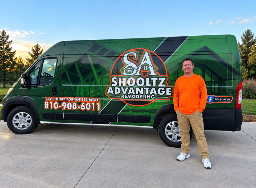 Man standing beside a green SHOOlTZ Advantage service van with orange logo and phone number on the side.