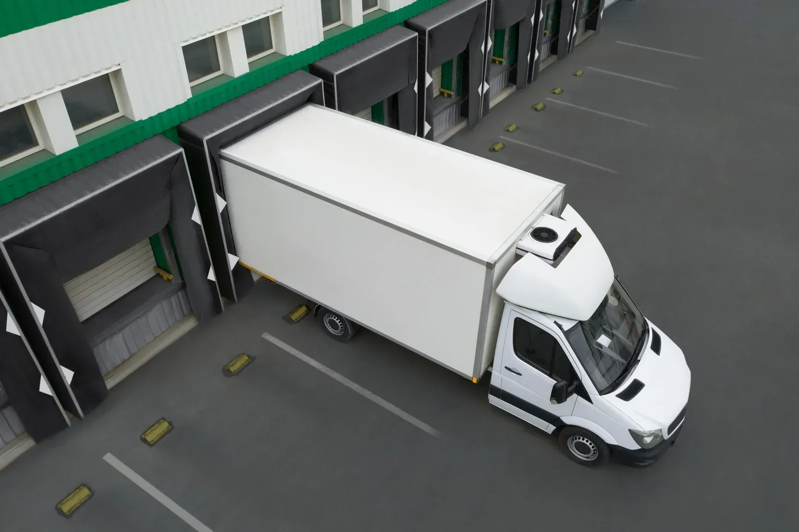 A forklift is loading a container onto a truck.