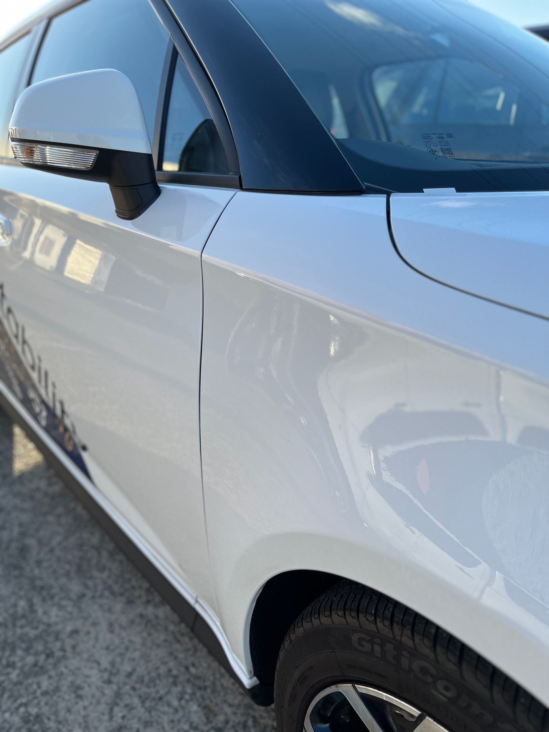 A white car is parked on the side of the road.