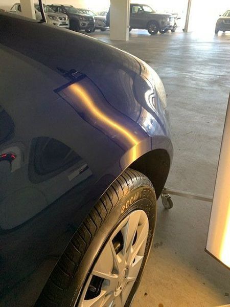 A Blue Car with A Dent in The Fender Is Parked in A Parking Garage — Dent Motive in Broadbeach, QLD