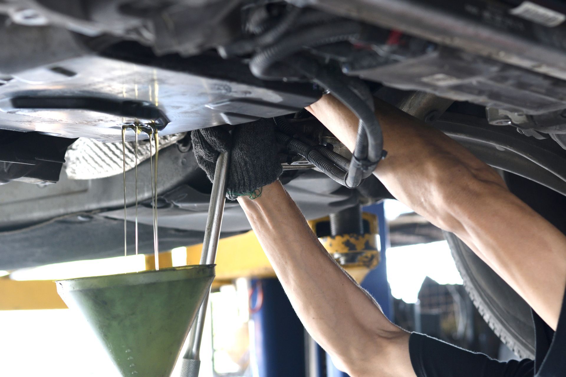 A man is working under a car with a wrench.