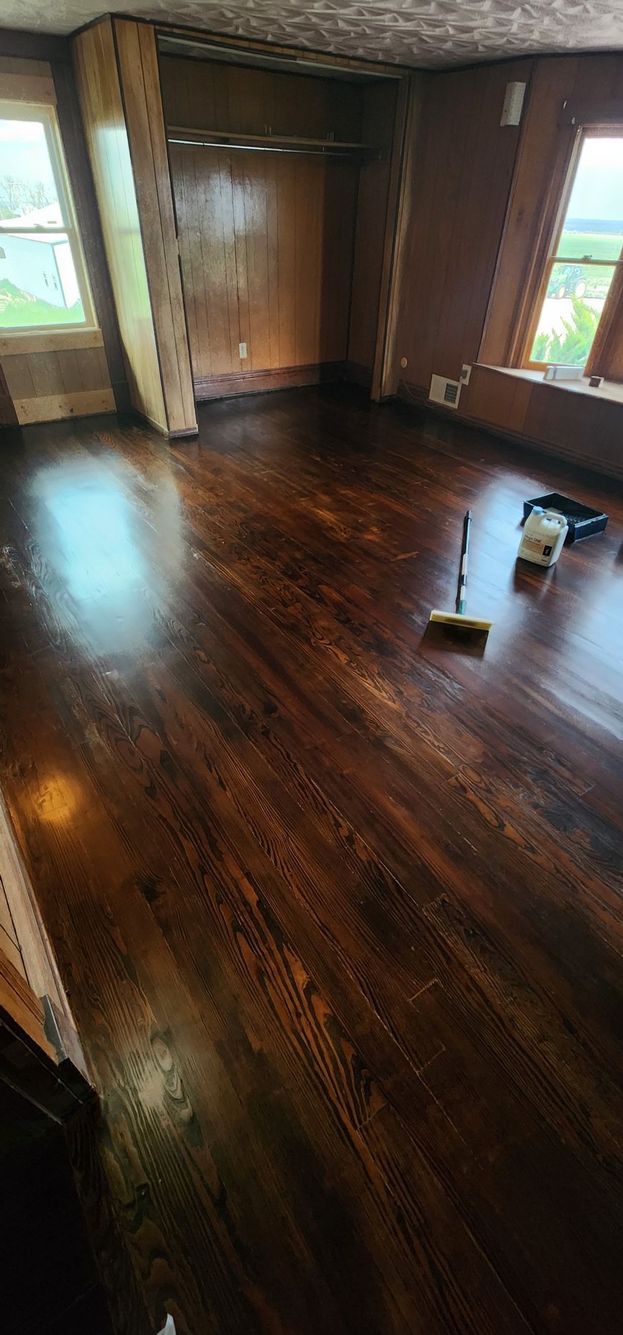 Room with dark stained hardwood floors, a closet, and windows.