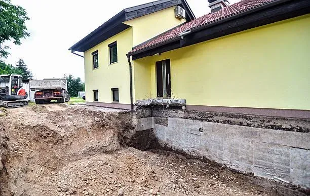 Home exterior with exposed foundation during structural repair