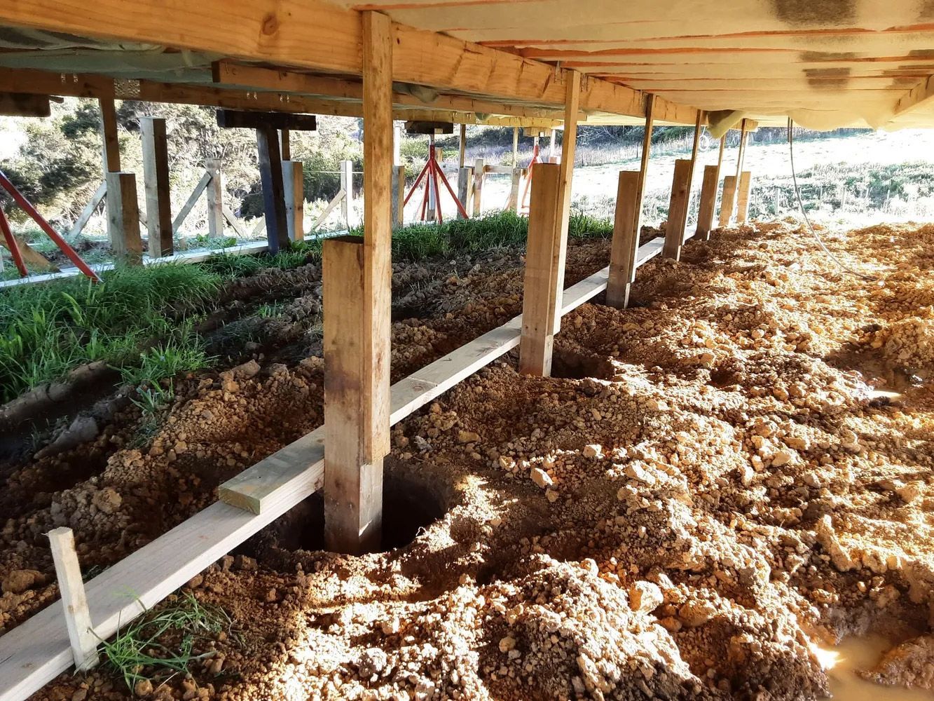 A wooden structure is being built under a pile of dirt.