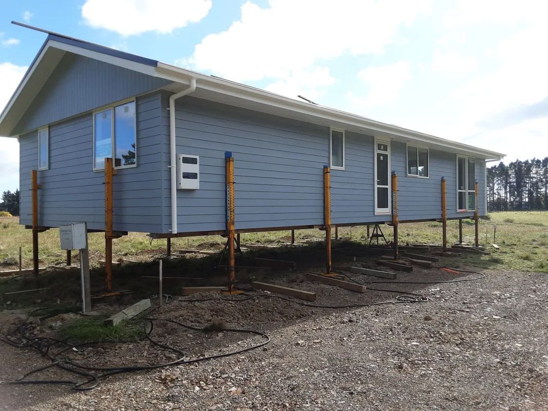 A house that is on stilts in a field