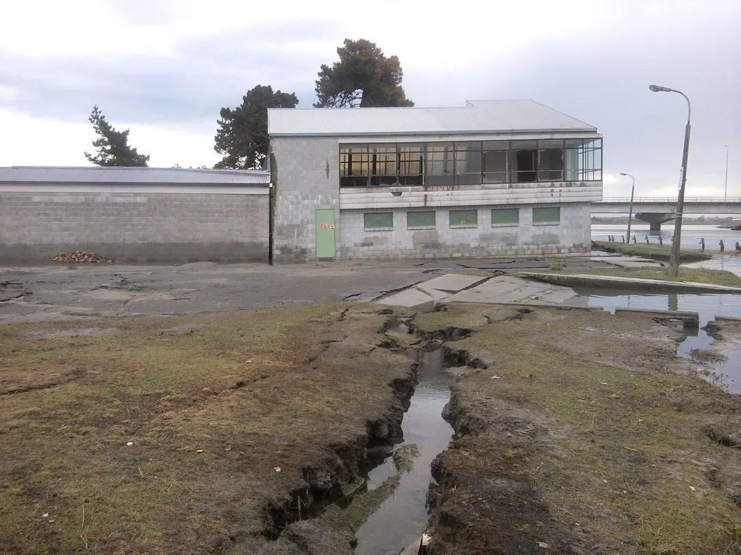 A building with a lot of windows and a drain in front of it