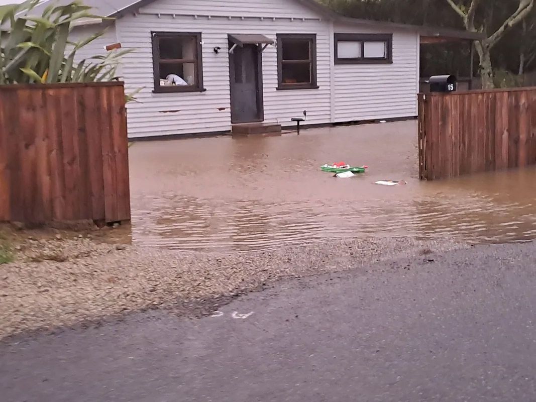 A flooded house with a wooden fence in front of it