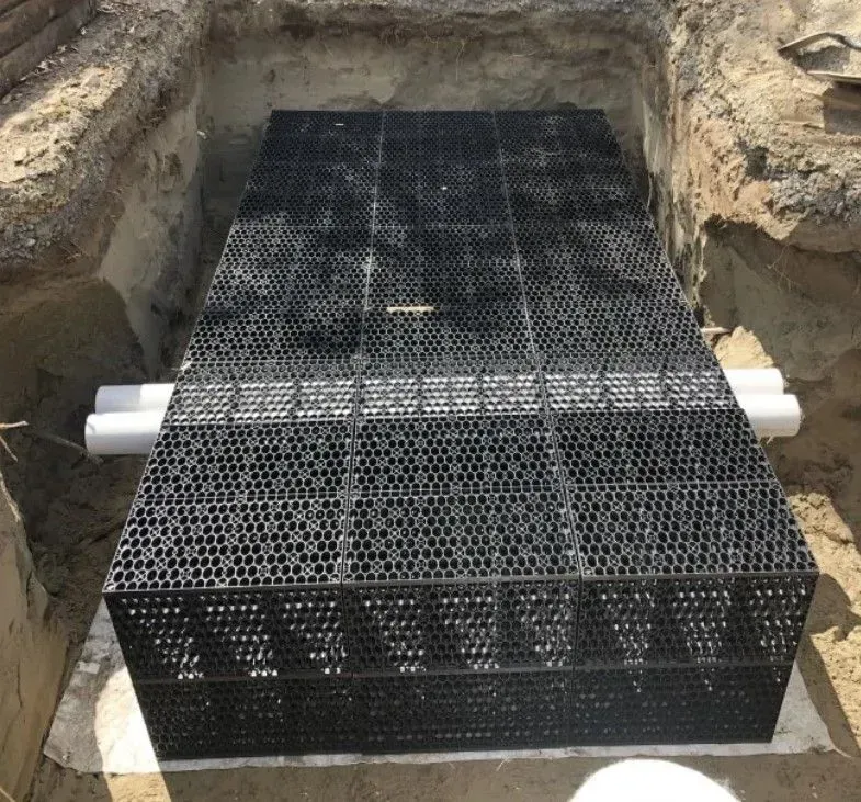 A large black box is sitting in a hole in the ground.