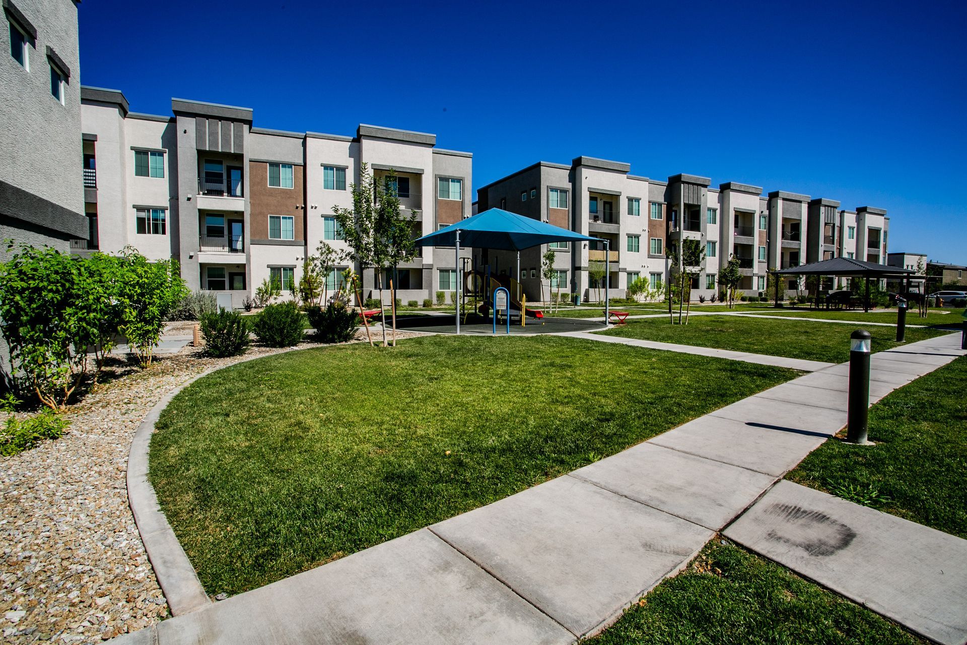 A large apartment building with a blue umbrella in front of it