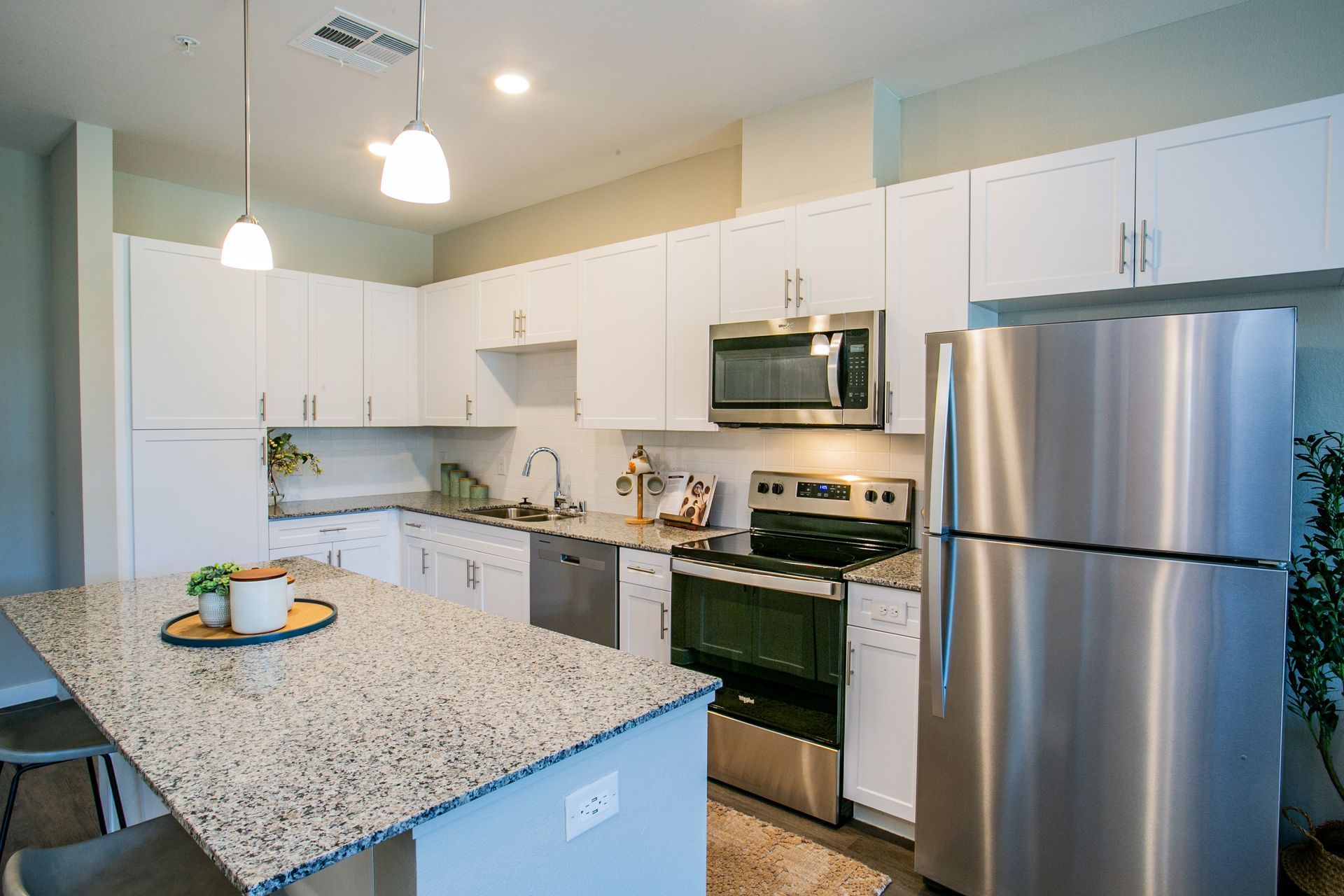 A kitchen with stainless steel appliances and granite counter tops.