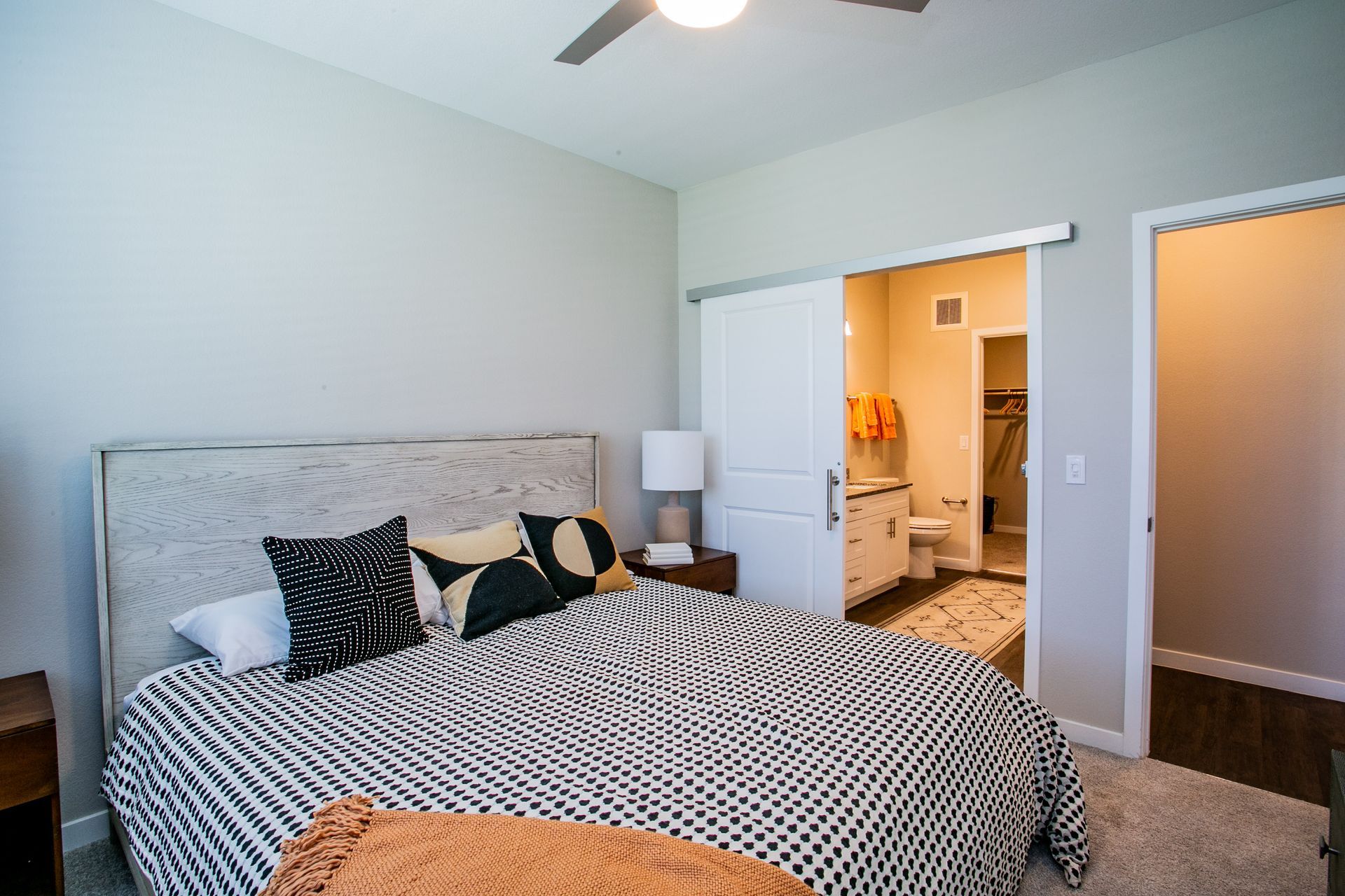 A bedroom with a large bed and a ceiling fan.