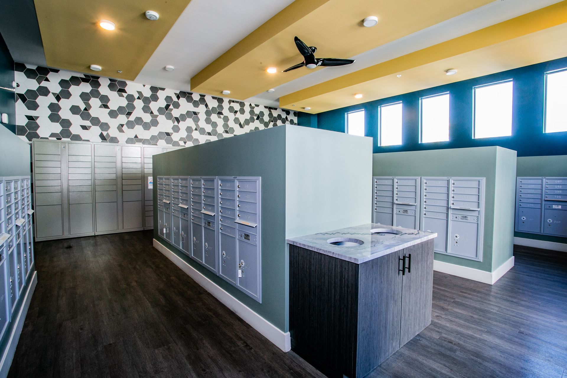 A room with a lot of mailboxes and a ceiling fan