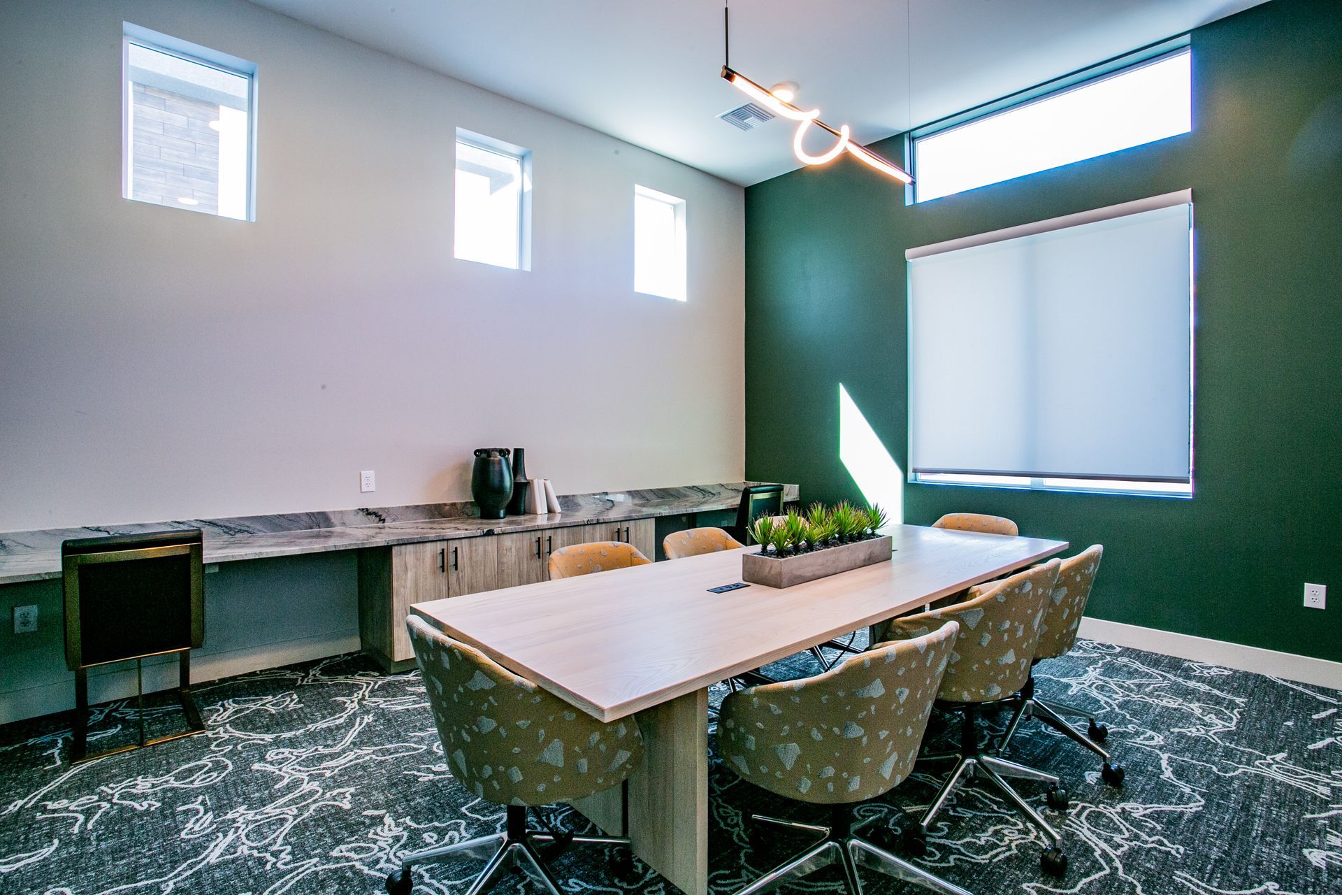 A conference room with a long table and chairs.