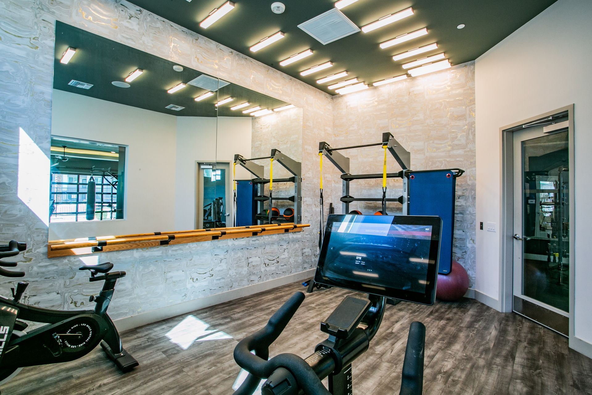 A gym with a bicycle and a large mirror.