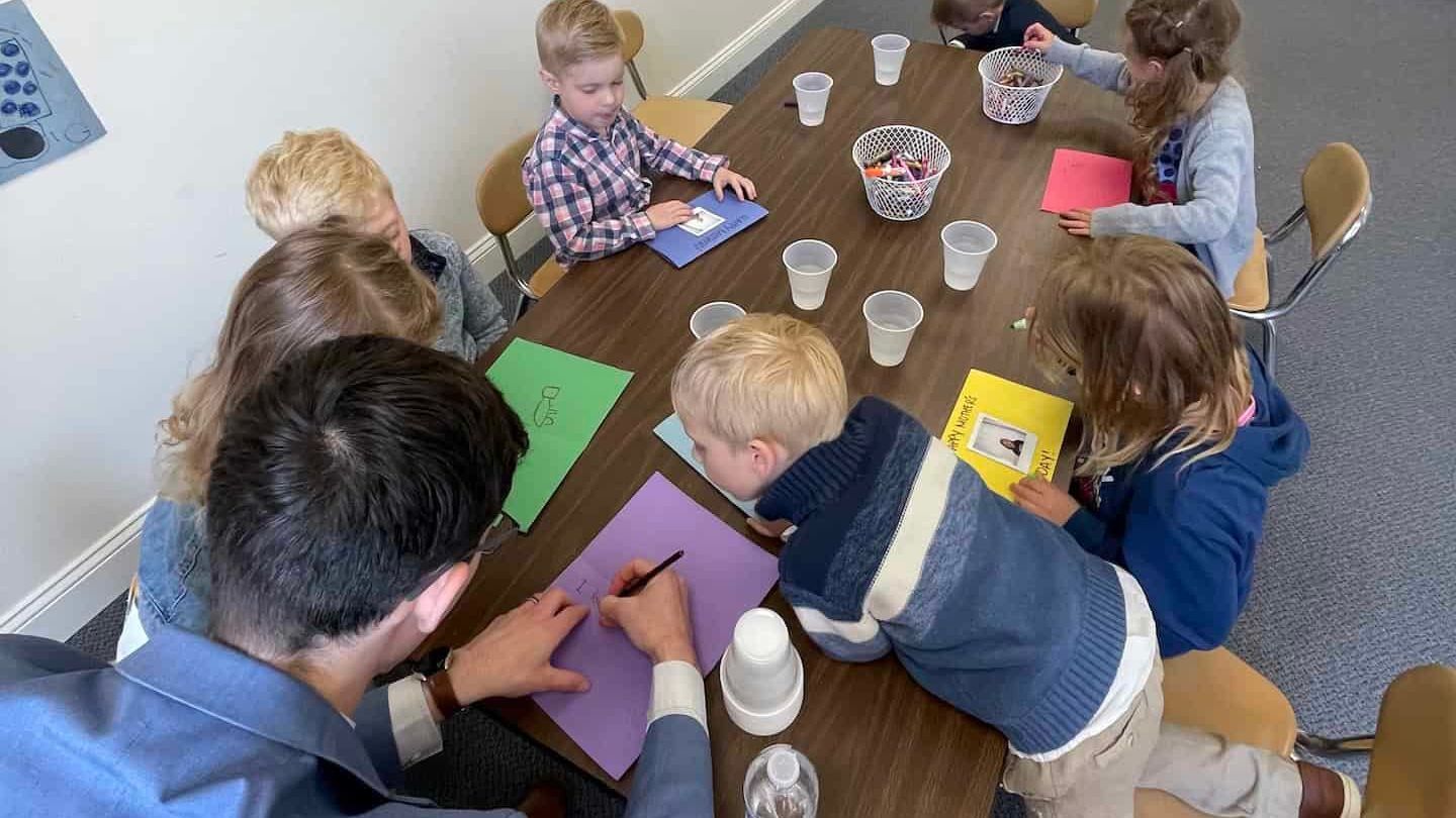 A group of children are sitting around a table.