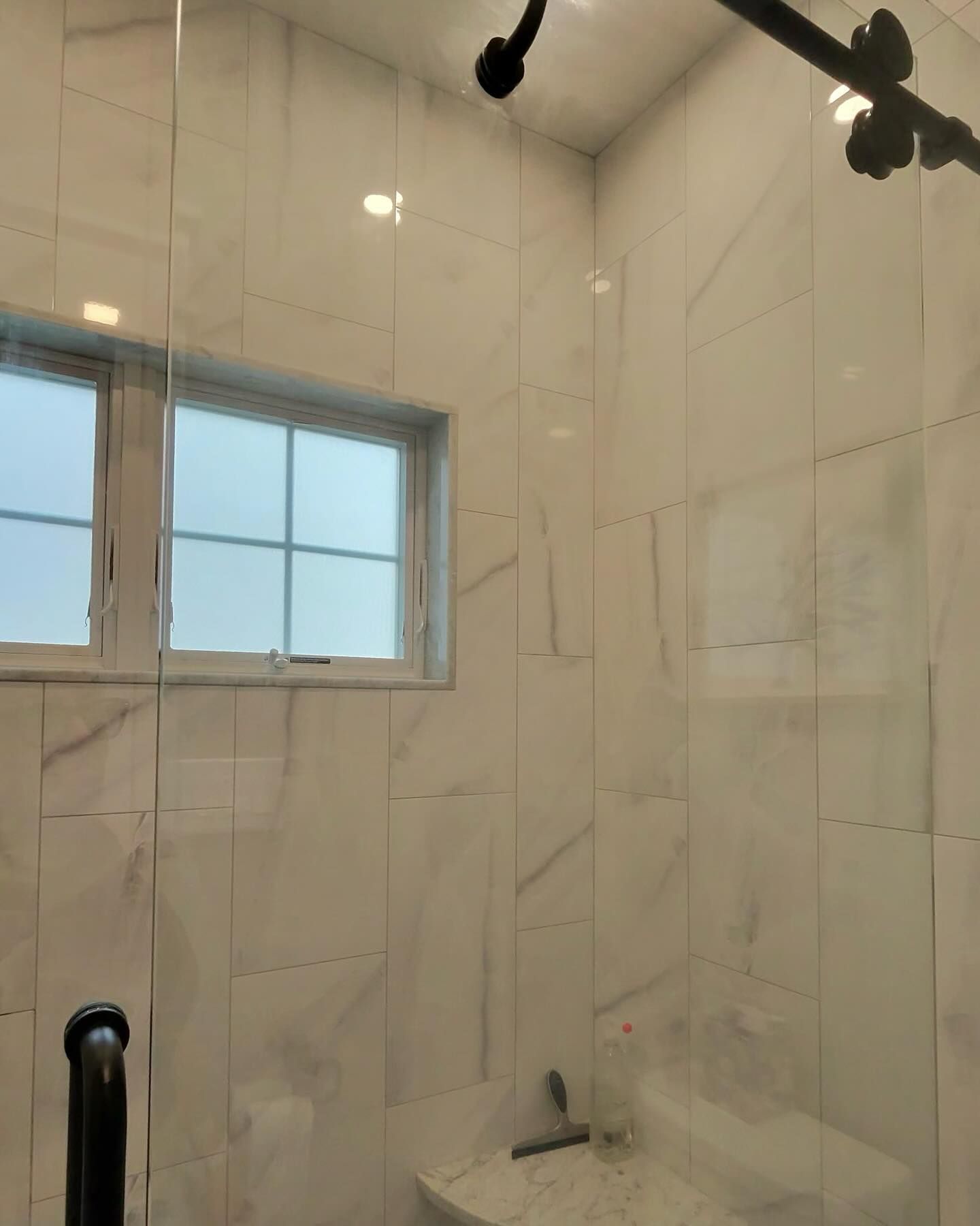 A bathroom with white tiles and a window