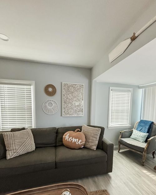 A living room with a couch and a pillow that says home